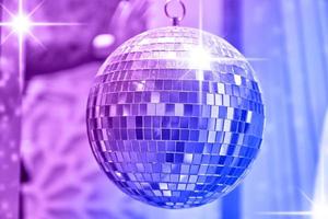 Disco ball with bright rays of lights, party background photo