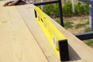 Yellow building level . working tool on wooden background photo