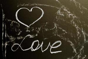 A chalk board with the word love and a heart. Grunge background texture photo