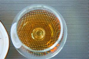 Snifter wine glass with cognac or brandy on a table. Top view photo