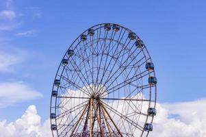 Big atraktsion ferris wheel on the background of a beautiful blue sky with clouds photo