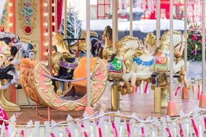 Colourful carnival Horses on a merry-go-round carousel in the amusement park photo
