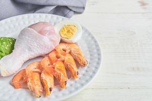 buenas fuentes de grasa en un plato: pollo, mariscos, huevo, aguacate, sésamo. concepto de alimentación saludable y dieta cetogénica foto