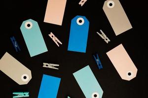 Background of blue, gray and pink  paper card tags for presents and wooden  clothespins for decoration. photo