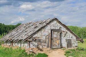 wooden house at the edge of the forest under dramatic sky photo