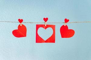 Paper Love hearts hanging on rope on a blue background photo