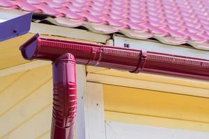 red gutter on the roof top of house photo