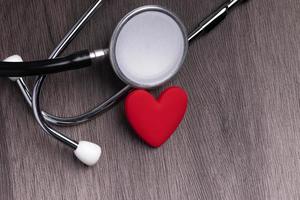 Stethoscope with red heart on gray background. Heart health care concept. photo