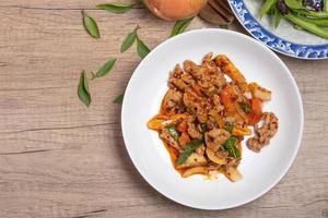 Pork stir fried in chili paste with tomatoes and onions in a white dish photo