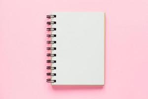 Top view of open empty notebook on pastel pink colorful background photo