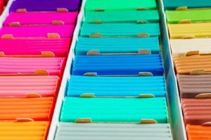 Rainbow colors of modeling clay. Multicolored plasticine bars ina box, background texture photo