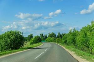 empty car road through the forest in summer day in Russia photo