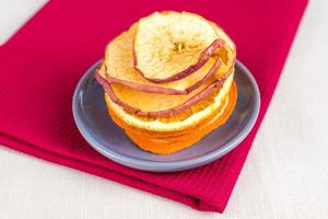 Healthy food organic nutrition. Sliced and dried apple, orange on textile background. photo