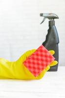 woman hand in yellow rubber glove holding cleaning sponge. . Cleaning product. photo