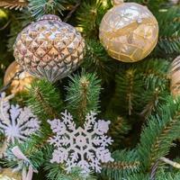 close up of christmas tree decorated with gold and white balls and snowflake. New year background photo