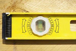 Yellow building level . working tool on wooden background photo