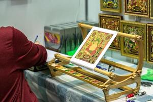 Moscow, Russia ,2019 - Iconography.  Man making a new icon from gemstones and crystals at workshop. photo