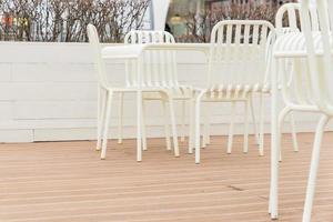 close up of empty street cafe with chairs and tables in white photo