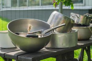 utensilios de cocina de metal antiguo sobre una mesa de madera al aire libre. estilo de vida rural. foto