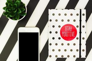 Modern creative workspace with white polka dot diary, succulent and smartphone. photo