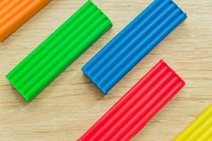 Set of multicolored plasticine bars for modeling on wooden table. Top view, eduction and creativity concept photo