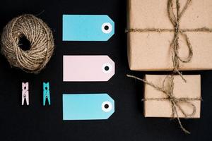 cajas de regalo hechas a mano envueltas en papel artesanal con etiqueta de tarjeta de papel azul, cuerda y pinzas de madera para la decoración. foto