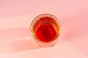 glass of apple juice on pink background. Non alcoholic beverage. photo