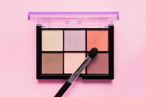 Set of nude eyeshadows in black case on pink background. Top view , copy space photo