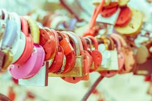 Plenty of multicolored love padlocks on metal railing of the bridge. selective focus, toned. photo