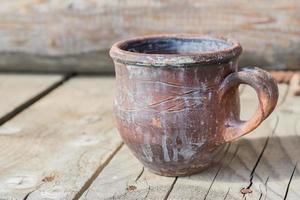 vieja taza de hierro oxidado sobre fondo de madera foto