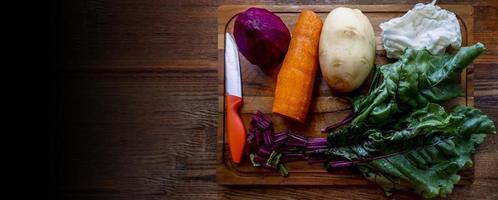 Board with ingredients for preparing tasty borscht on white background photo