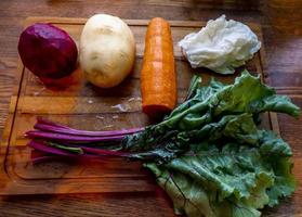 Board with ingredients for preparing tasty borscht on white background photo