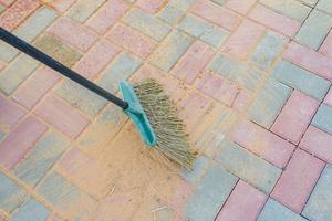 Broom swipes paved walkway grouted with sand
