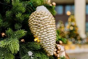 close up of christmas trees decorated with sparkling cones and garland with lights on. Festive background with copy space for your projects photo