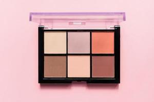 Set of nude eyeshadows in black case on pink background. Top view , copy space photo