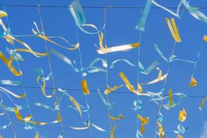 festive background - blue and golden satin ribbons against blue sky. photo