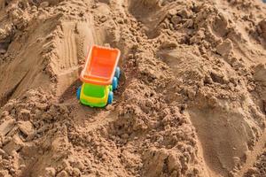 camión de juguete pequeño trabajando en cantera de arena, concepto de construcción, espacio de copia foto