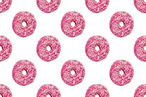 pink frosted donuts with white sprinkles on white background. Seamless pattern photo