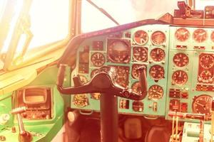 pilot seat in the old plane. Steering wheel and control panel in the cockpit, toned photo