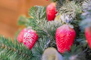 Christmas and New Year holidays background.  Christmas tree decorated with strewberry, selective focus. Celebration concept photo