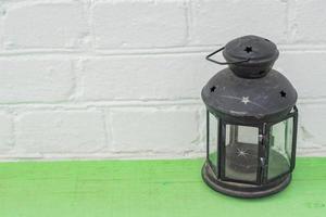 Old vintge black rusty lantern on green shelf, home interior decoration photo