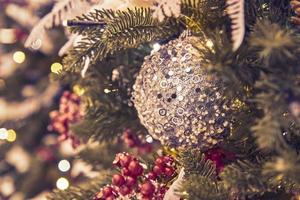close up of christmas tree decorated with silferr sparkling balls and garland with lights on. Festive background with copy space for your projects photo