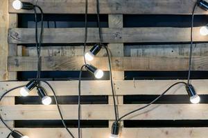 Loft style background. Garland with bulbs and wooden pallet on the wall photo