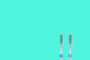 Two toothbrushes  on blue background. Top view, minimal flat lay. photo