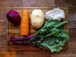 Board with ingredients for preparing tasty borscht on white background photo