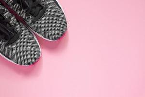 Sport Shoe on pink background. Black and white female sneakers for training. Lifestyle concept with copy space. Top view photo