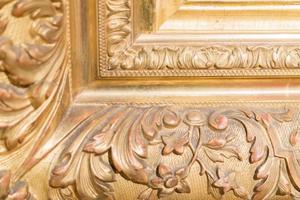 close up of rustic baguette of the painting. gold carved flowers and leaves photo