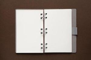 Top view of open empty notebook with cover from recycled paper on brown background photo