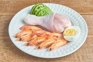 buenas fuentes de grasa en un plato: pollo, mariscos, huevo, aguacate, sésamo. concepto de alimentación saludable y dieta cetogénica foto