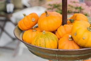 Small orange pumpkins in metall basket. Rustic style. Stall at Farmers market. photo